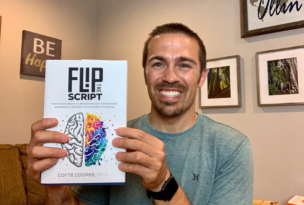 Coyte Cooper holding the finished hardcover edition of Flip the Script.