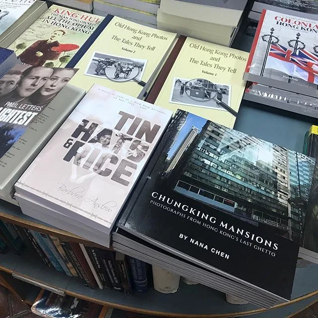 Tin Hats and Rice on a Hong Kong history table, the title reading from standing height among quieter photographic covers.