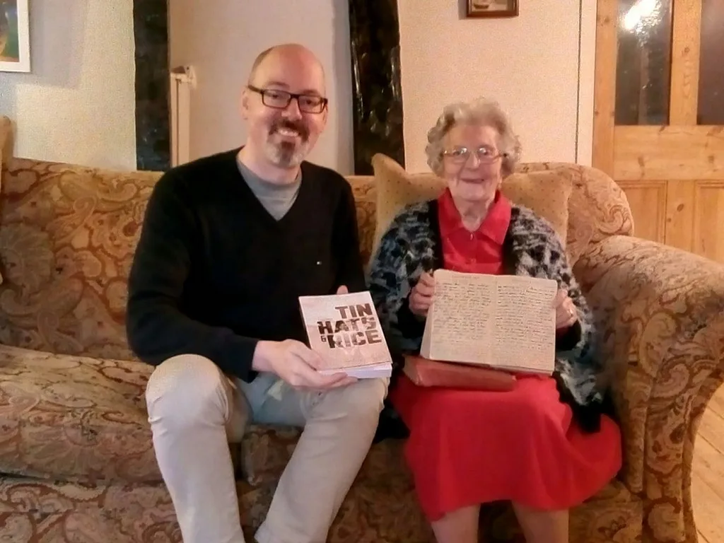 Barbara Anslow with her publisher, holding one of the original handwritten diaries the book was set from.